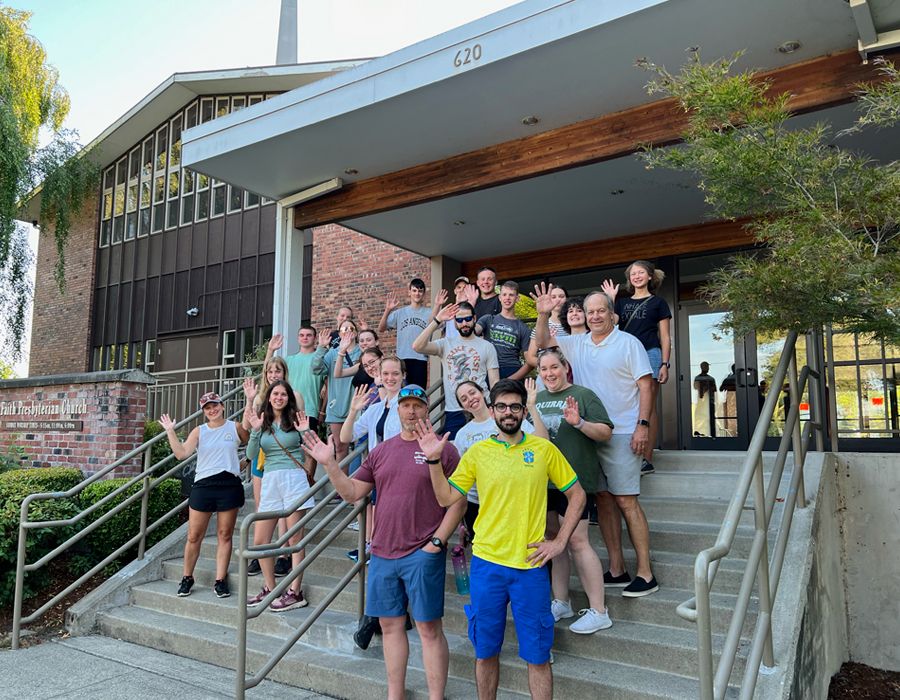 Members of Faith Presbyterian Church waving on the church steps.